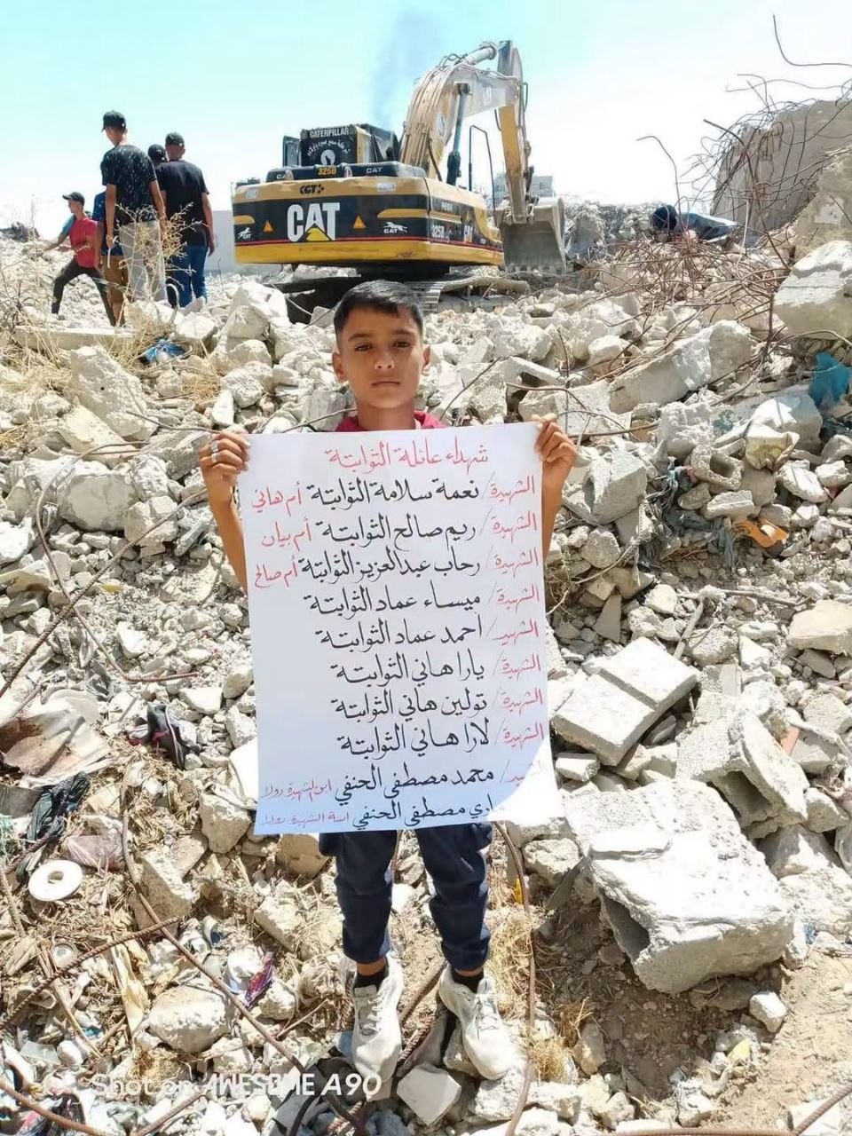 This Palestinian child bears the names of 10 of his family members buried under a building destroyed